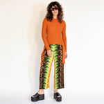 A model wears the green orange and black graphic printed pleated pant - full outfit view.