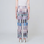 Pleated high waist trousers with a gridded graphic pattern in greys, whites, and blues - back view on model.