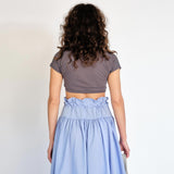 A model wears the super cropped medium grey Joni Tee from Maryam Nassir Zadeh - back view.