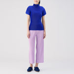 Full body photo of model wearing the Thicker Bottoms Pants - Pink Purple, a pleated straight leg pant.