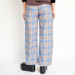 A model wears the wide-leg Lawn checked pant in a blue sky plaid - back view.
