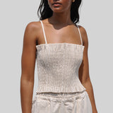 Photo of a model wearing the MEALS - Lettuce Stretch Top in flour (off white), a ruched top with shoulder straps.