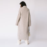 Back view of the Long Shawl Cardigan by Lauren Manoogian, with deep front pockets and wide sleeves, paired with white pants.