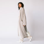 Side view of the Long Shawl Cardigan by Lauren Manoogian, with deep front pockets and wide sleeves, paired with white pants.
