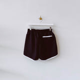 Vintage style running short in black with white piping and Marine Serre embroidered logo on front left thigh - back view.