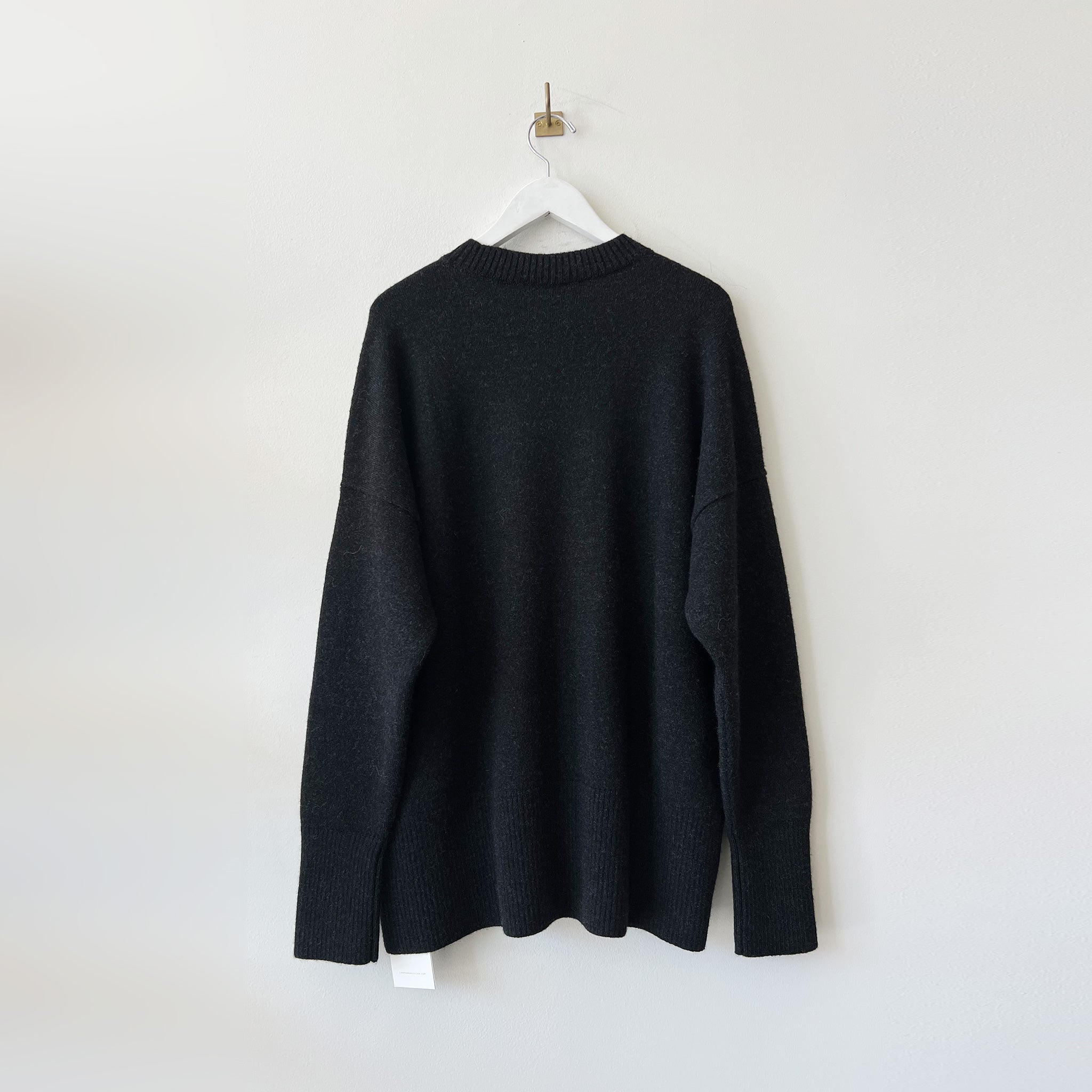 Oversized black melange crewneck sweater with long sleeves - back viwe.