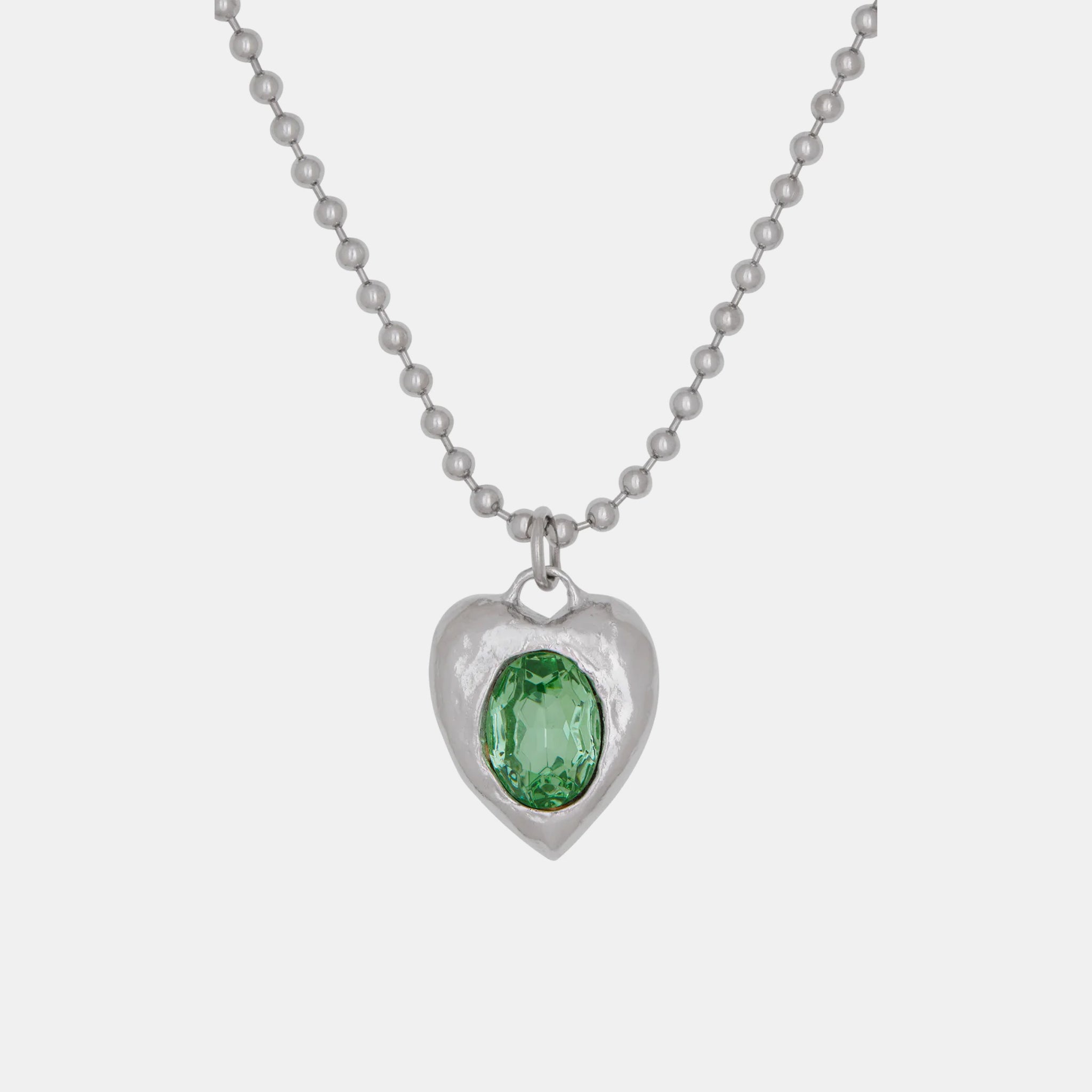 A silver-toned roughly shaped heart pendant necklace featuring a clear green stone - detailed image.