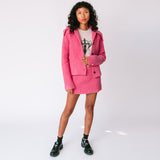 A model wears the chunky ribbed pink Paw Cardigan unbuttoned with the matching Barb ribbed skirt, full outfit view.