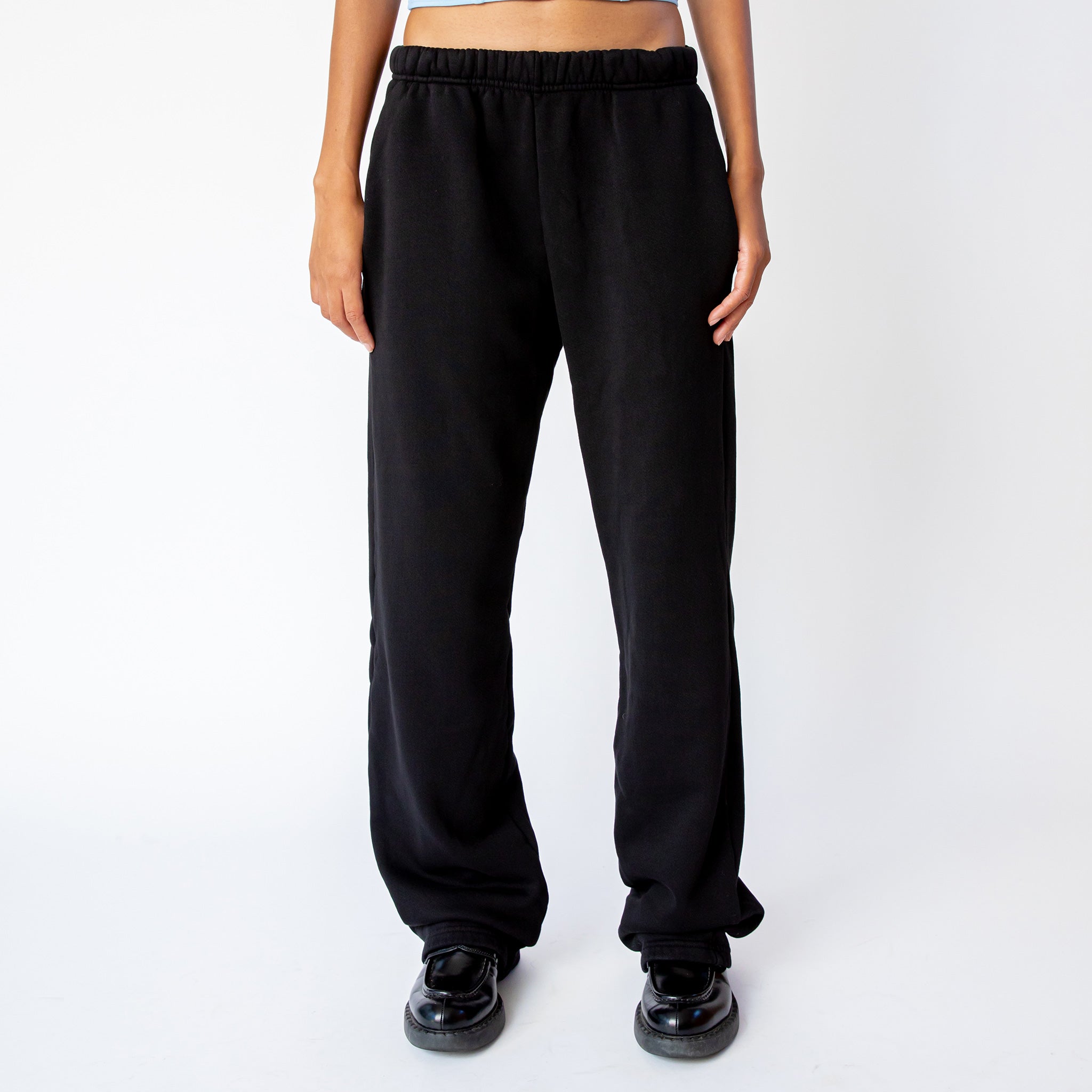 A model wears the Les Tien Puddle Pant in Jet Black, a long, straight-legged sweatpant with extra length that puddles at the feet - front view.