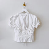 Back hanging photo of the Puff Sleeve V-Neck Top - White.