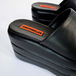 Back sole detail of the Puffed Blackout Platform, showing the orange Simon Miller label.