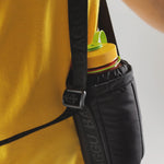 Close detail photo of model wearing the Puffy Water Bottle Sling - Black.
