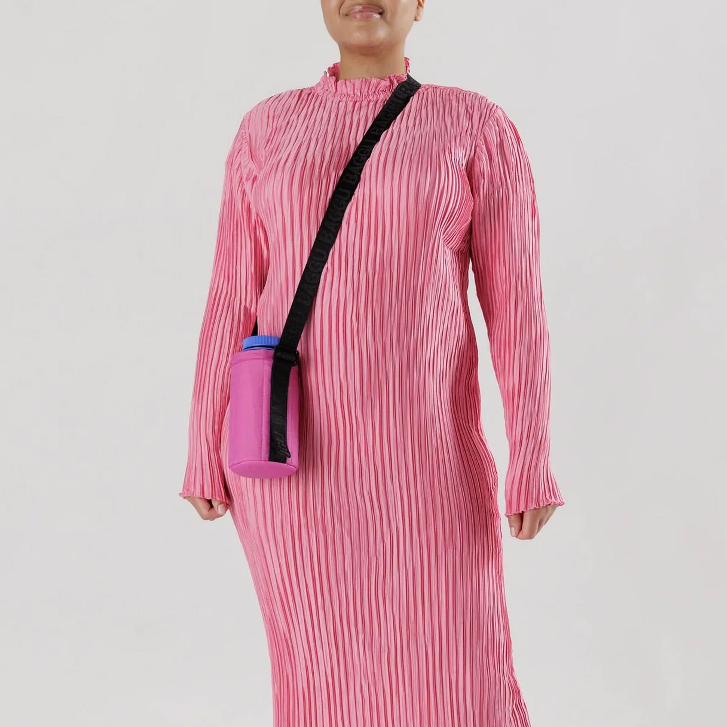 Close half body photo of model wearing the Puffy Water Bottle Sling - Extra Pink.
