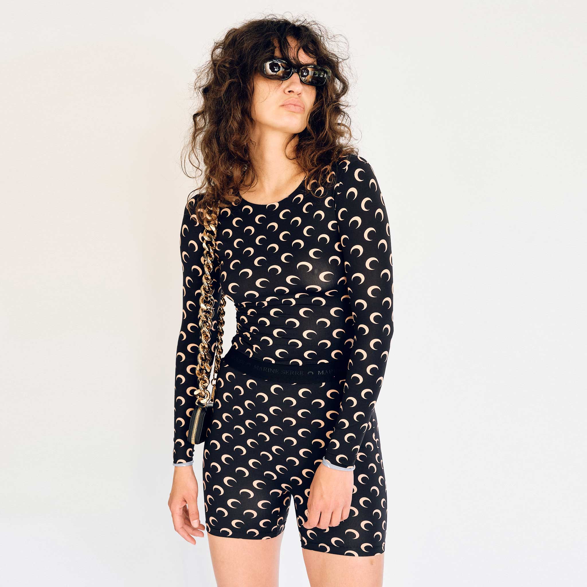 A model wears the long sleeved Regenerated Second Skin top in black with tan colored moon print - front view.