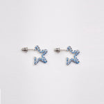 Small sterling silver earrings in the shape of a 5-pointed star with tiny blue rhinestones.