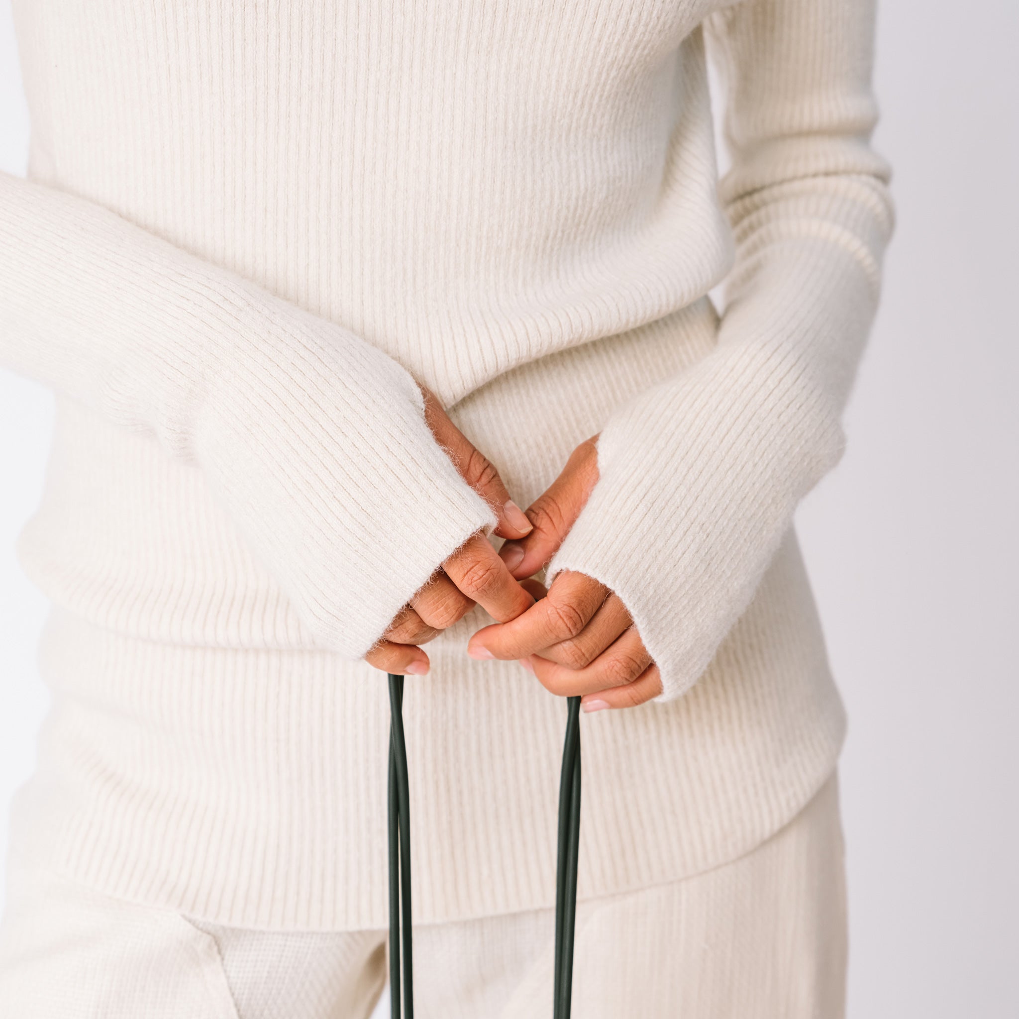 Detailed sleeve photo of the white ribbed mock neck by Lauren Manoogian, showing the thumb holes.