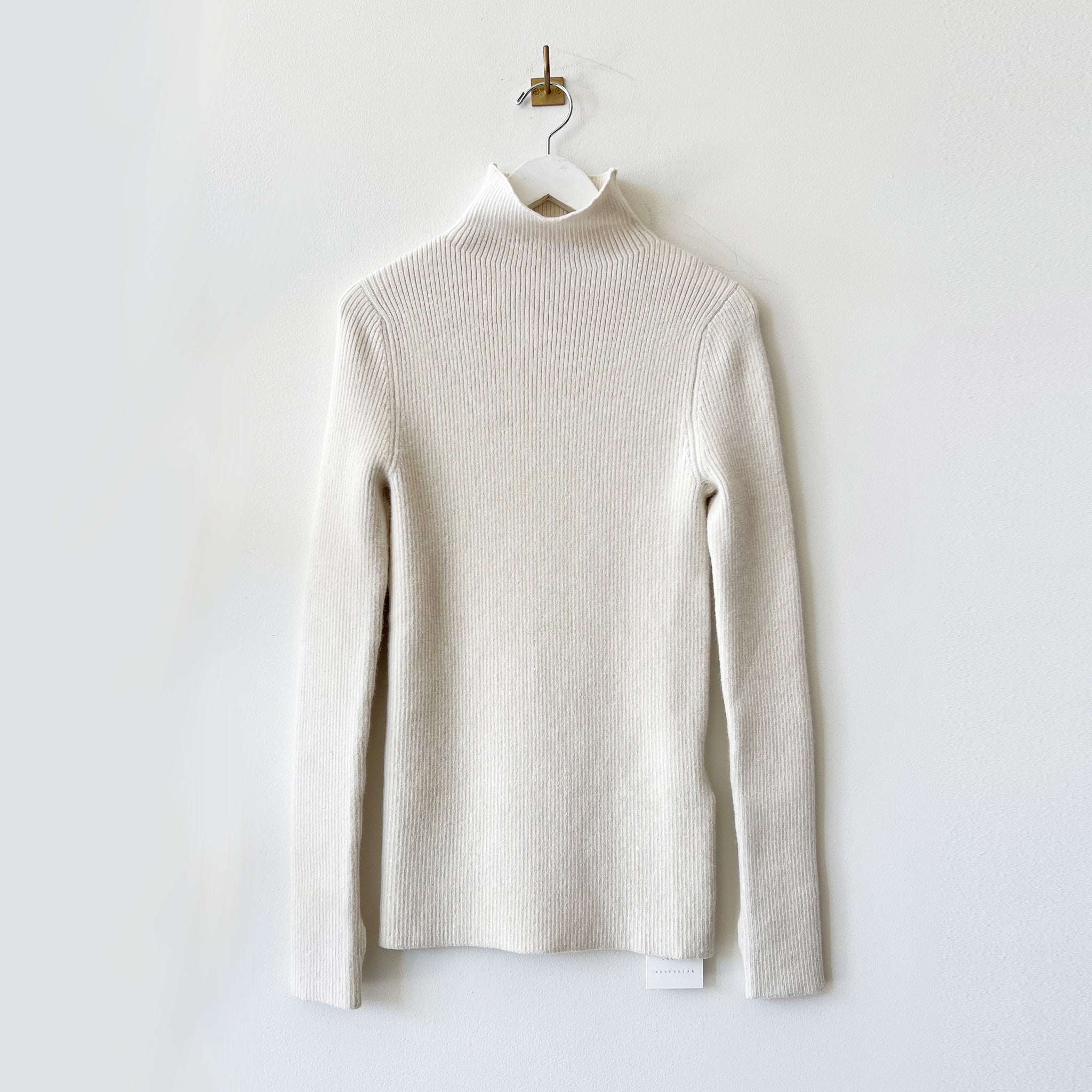 Ribbed white long sleeved mockneck sweater.