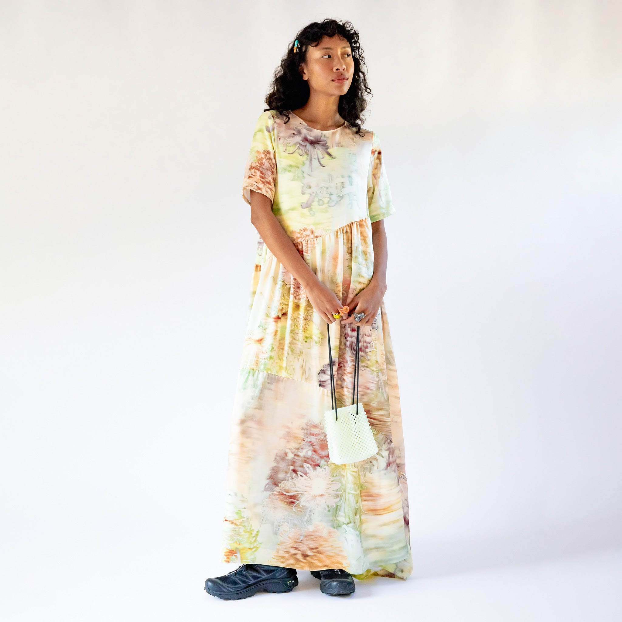 Front view of a model wearing the Ritual Dress - Light Chrysanthemum, a full length short-sleeved printed dress with a crew neck and large paneled pieces.