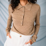 A close up of amodel wears the lightweight brown cardigan by Sandy Liang paired with a white mink skirt.