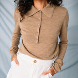 A close up of amodel wears the lightweight brown cardigan by Sandy Liang paired with a white mink skirt.