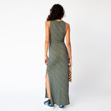 A model wears the form-fitting Shrunk Dress by Eckhaus Latta, a sleeveless full length casual dress in a green printed pattern, back view.
