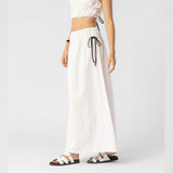 Side half body photo of model wearing the Cotton Side Ribbons Midi Skirt - White.