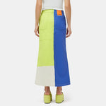 Close half body photo of model wearing the Simi Skirt - a full length denim skirt painted in color blocks of chartreuse, blue, and white - back view.
