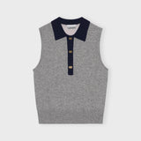 A model wears the frost gray sleeveless polo top with contrasting navy blue collar and gold button hardware - flat image.