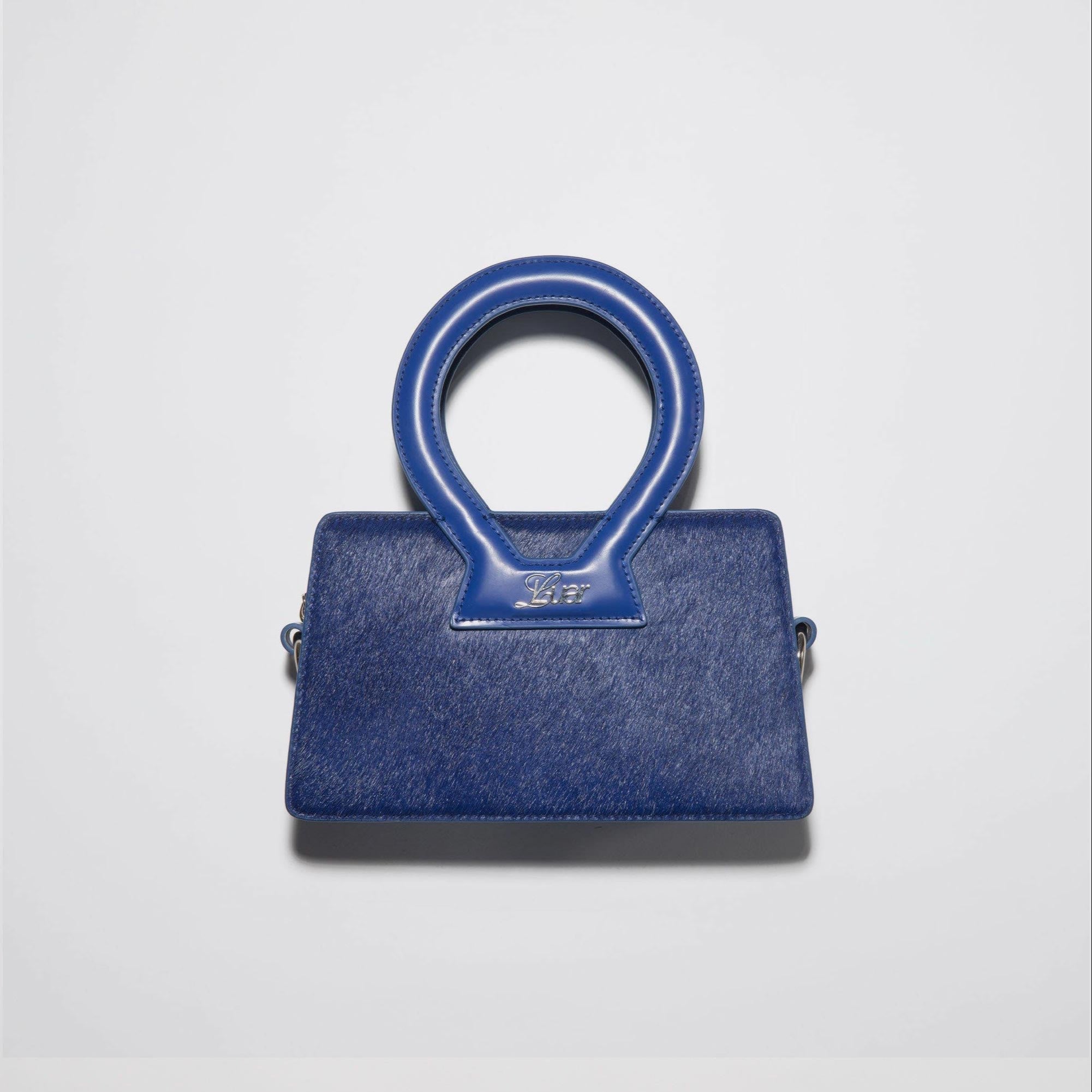 Front photo of Luar's Small Ana Bag, finished in a vibrant deep blue ponyhair, featuring a large circular top handle.