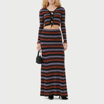 A model wears the black, red, and lavender striped maxi skirt, front view with matching cropped cardigan.