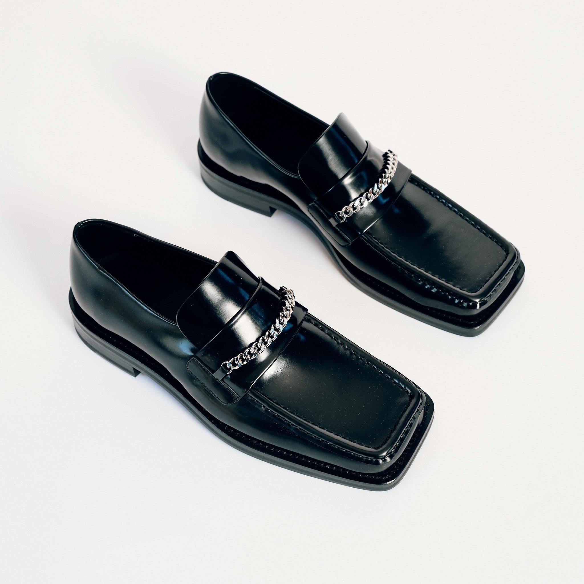 Martine Rose Square Toe Loafer in black shiny leather with a silver chain across the vamp - top view.