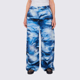 A model wears the cotton wide-legged Stomp Pant, featuring a blue and white aquatic inspired all over print, large front and side pockets, front view.