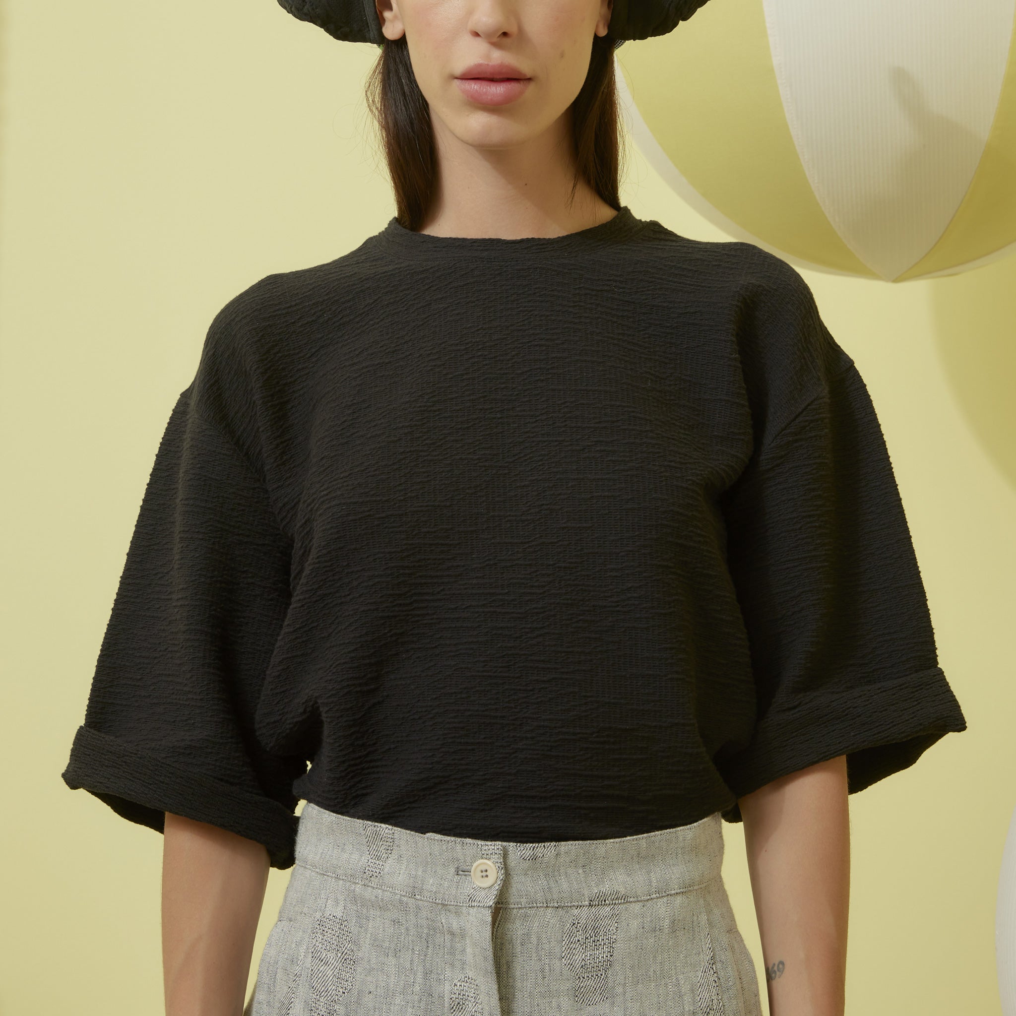 Black boxy fitted top with elbow-length short sleeves in a jacquard fabric.