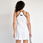 A model wears the white tennis court dress by Marine Serre - back view.
