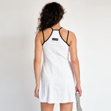 A model wears the white tennis court dress by Marine Serre - back view.