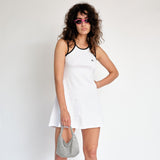 A model wears the white tennis court dress by Marine Serre - front view.