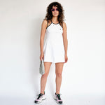 A model wears the white tennis court dress by Marine Serre - full outfit view.