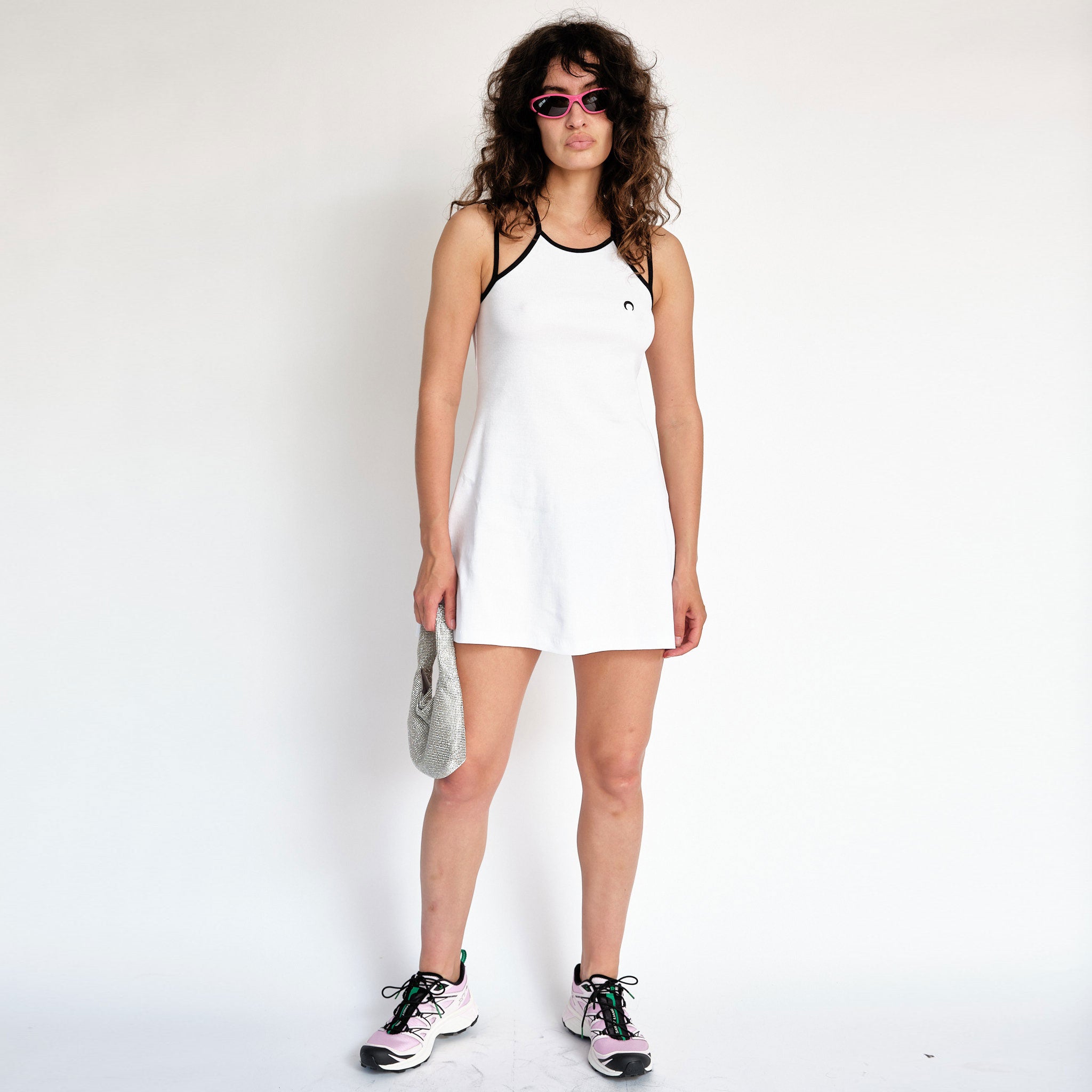 A model wears the white tennis court dress by Marine Serre - full outfit view.