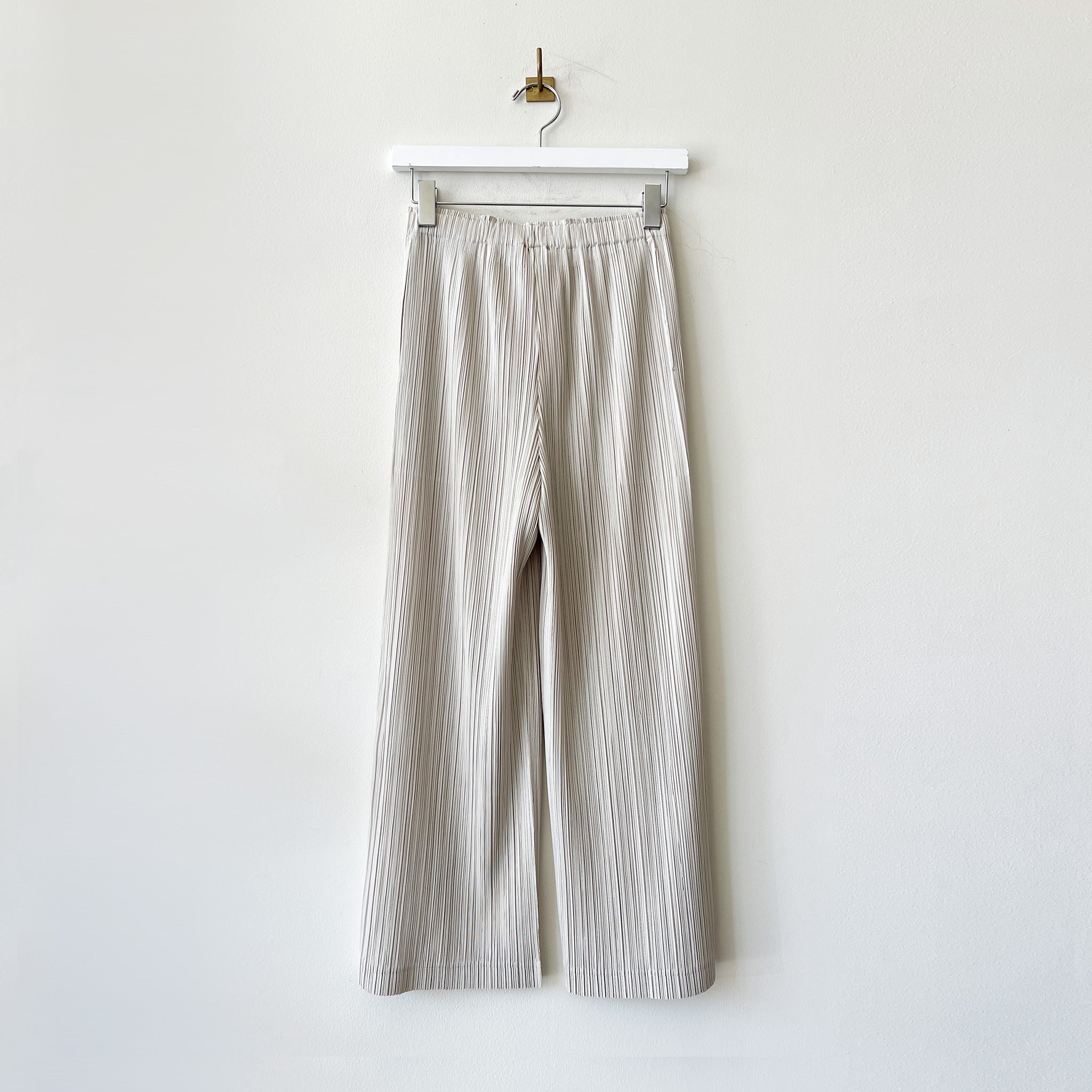 Medium-weight pleated pant in a light grey color way with hidden side pockets.