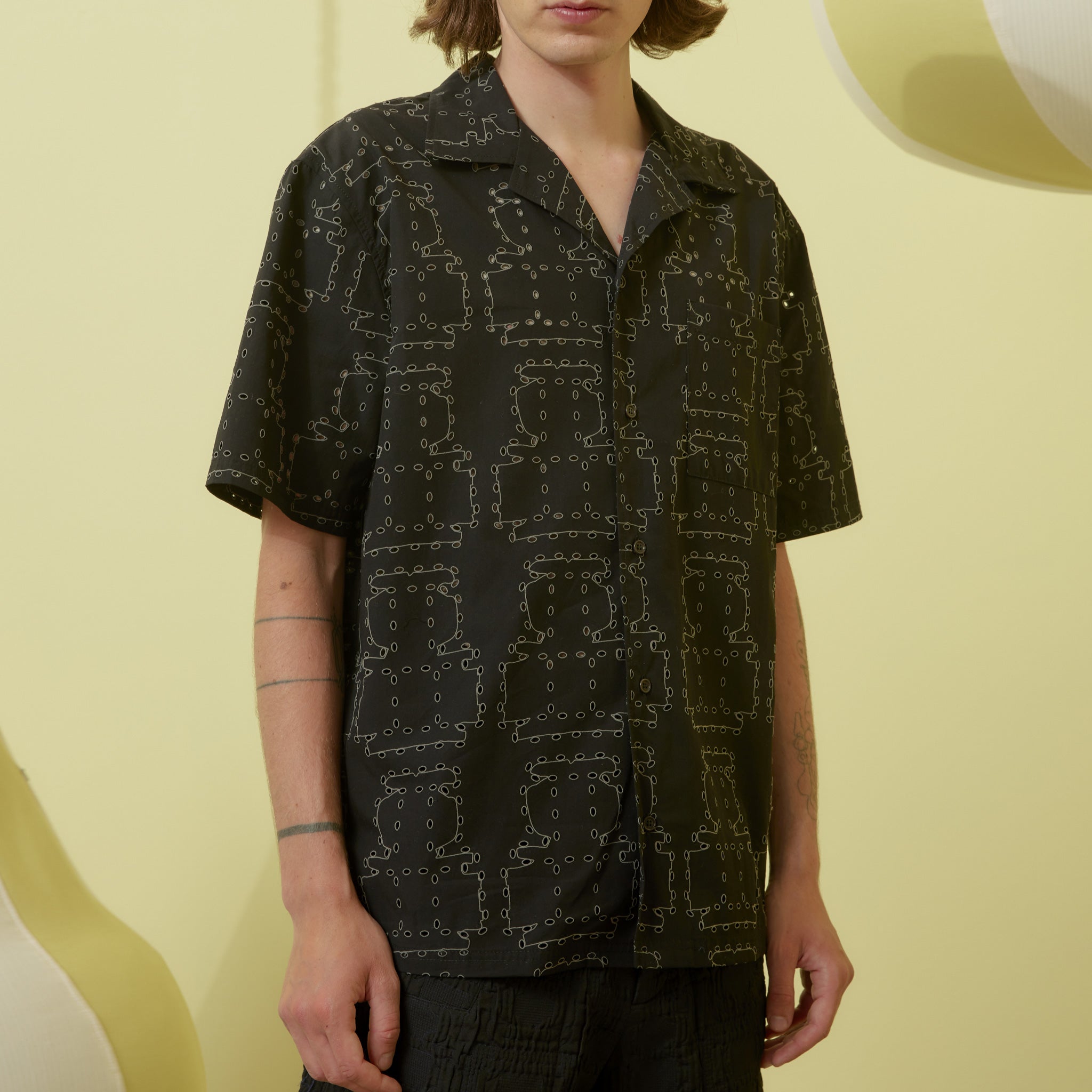 Mens black short-sleeve button up shirt with contrast stitching and eyelet details throughout.