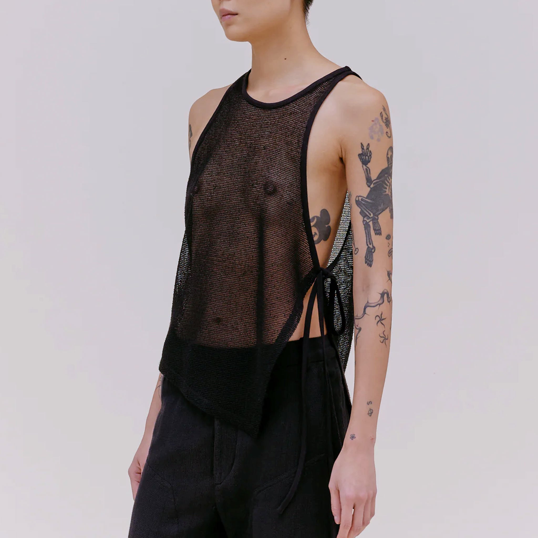 Side half body photo of model wearing the mesh UV tank in the color midnight.