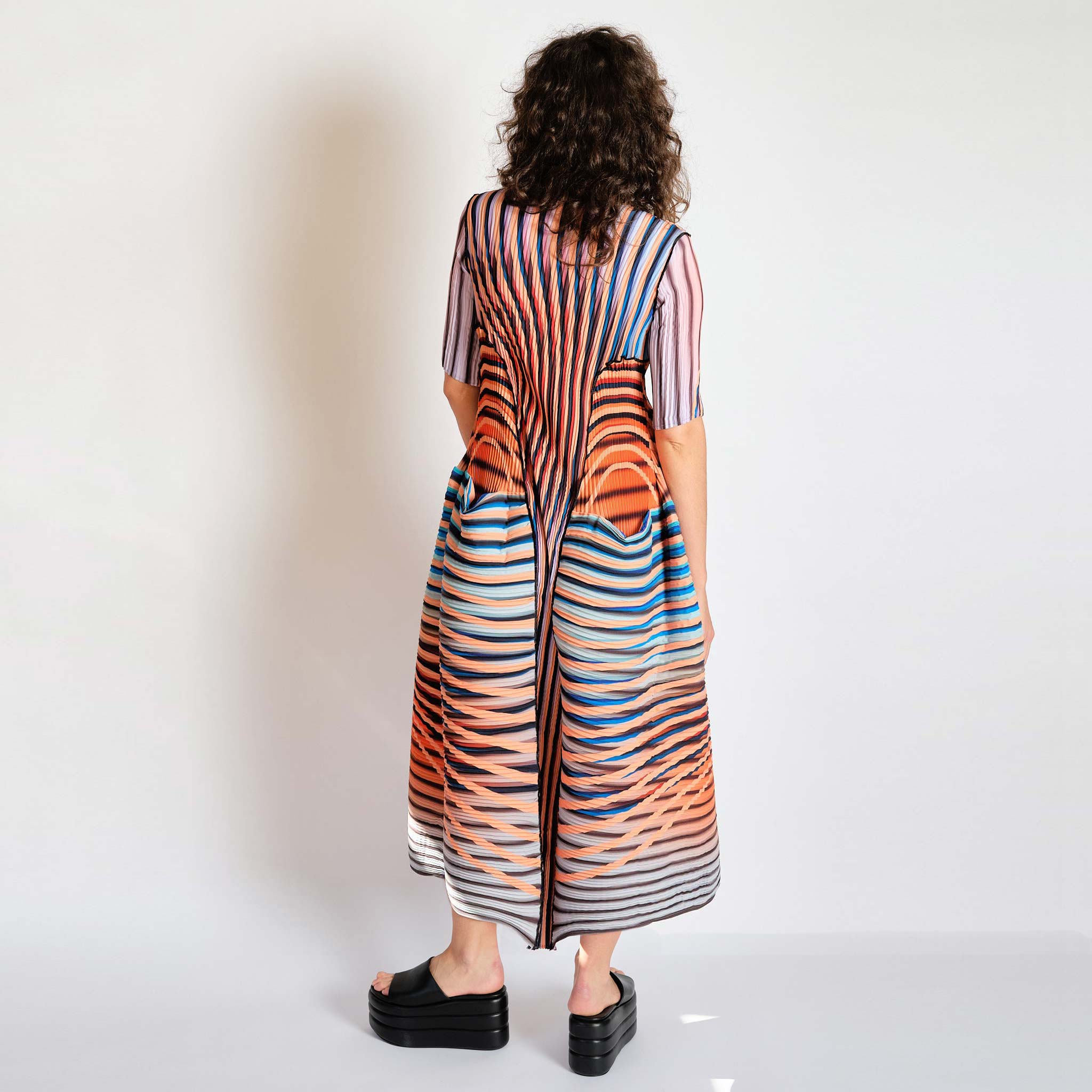 Bold striped and multicolored pleated dress, back view.