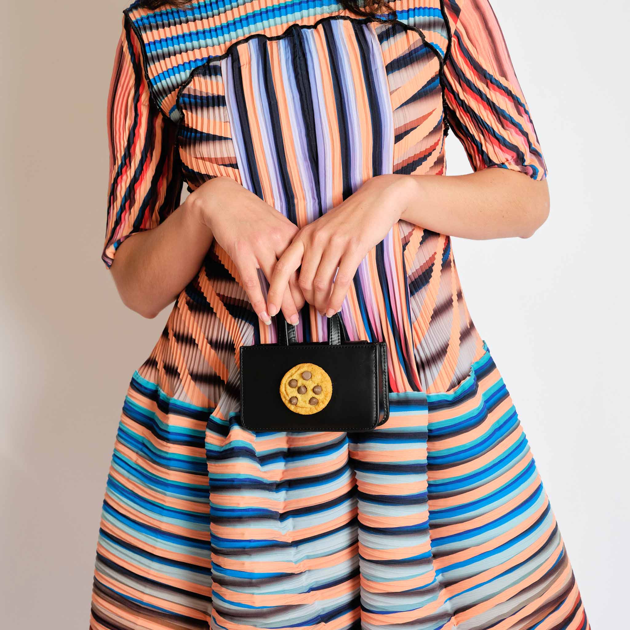 Bold striped and multicolored pleated dress, detailed view.