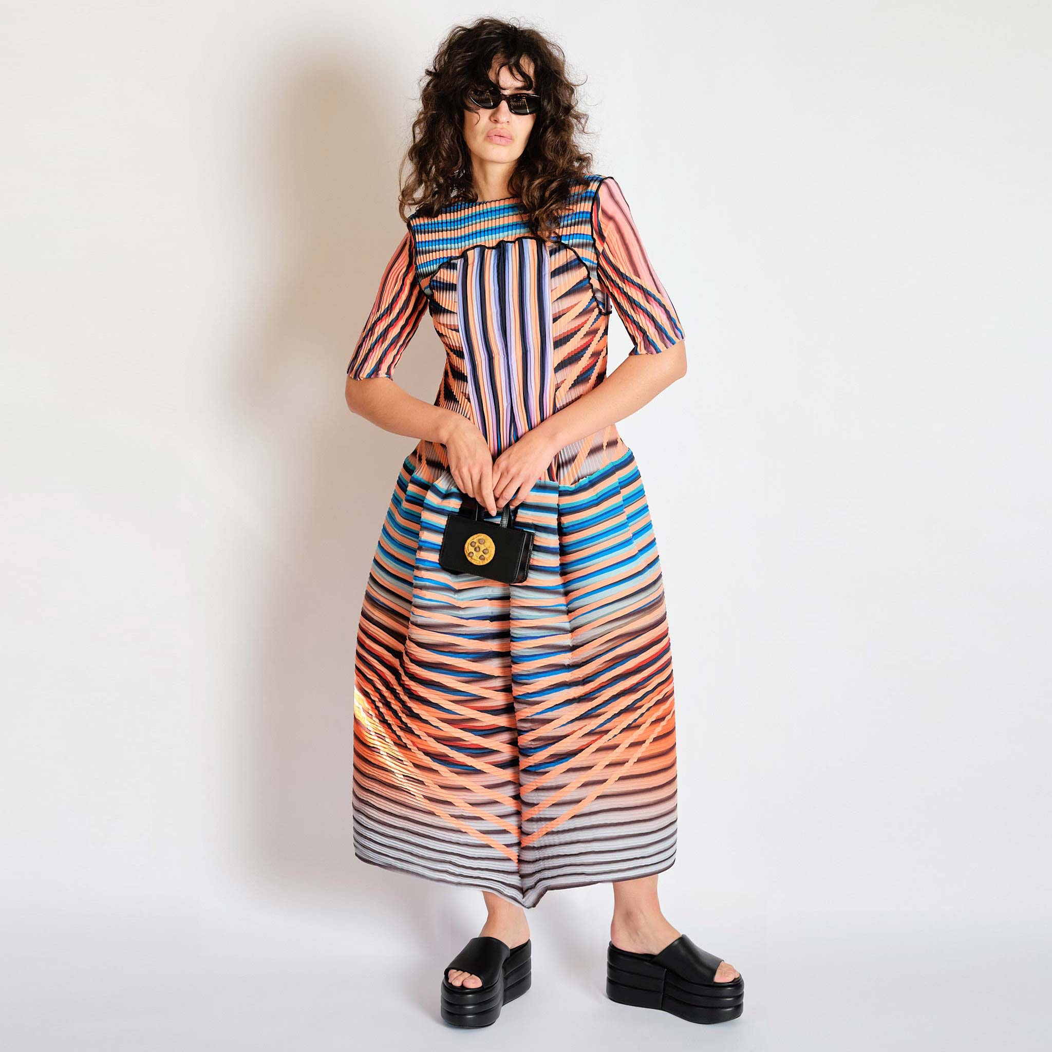 Bold striped and multicolored full-length pleated dress, front view.