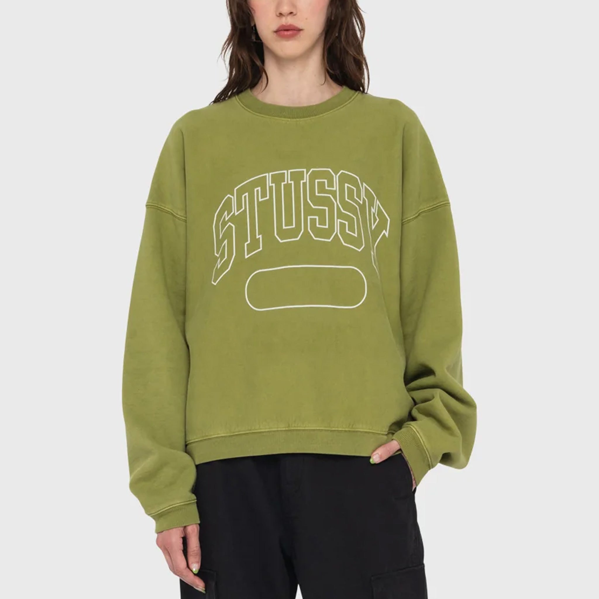 Front photo of model wearing a oversized stussy crewneck sweatshirt in a light green color.