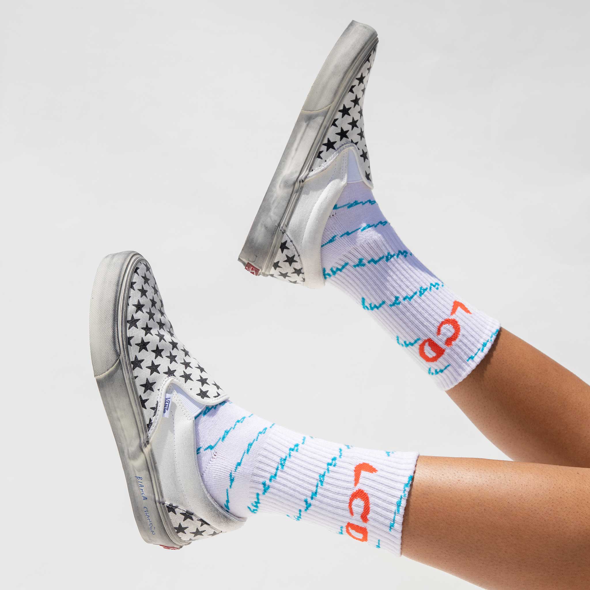 Photo of models feet wearing the LCD10 Motto Crew Socks. 