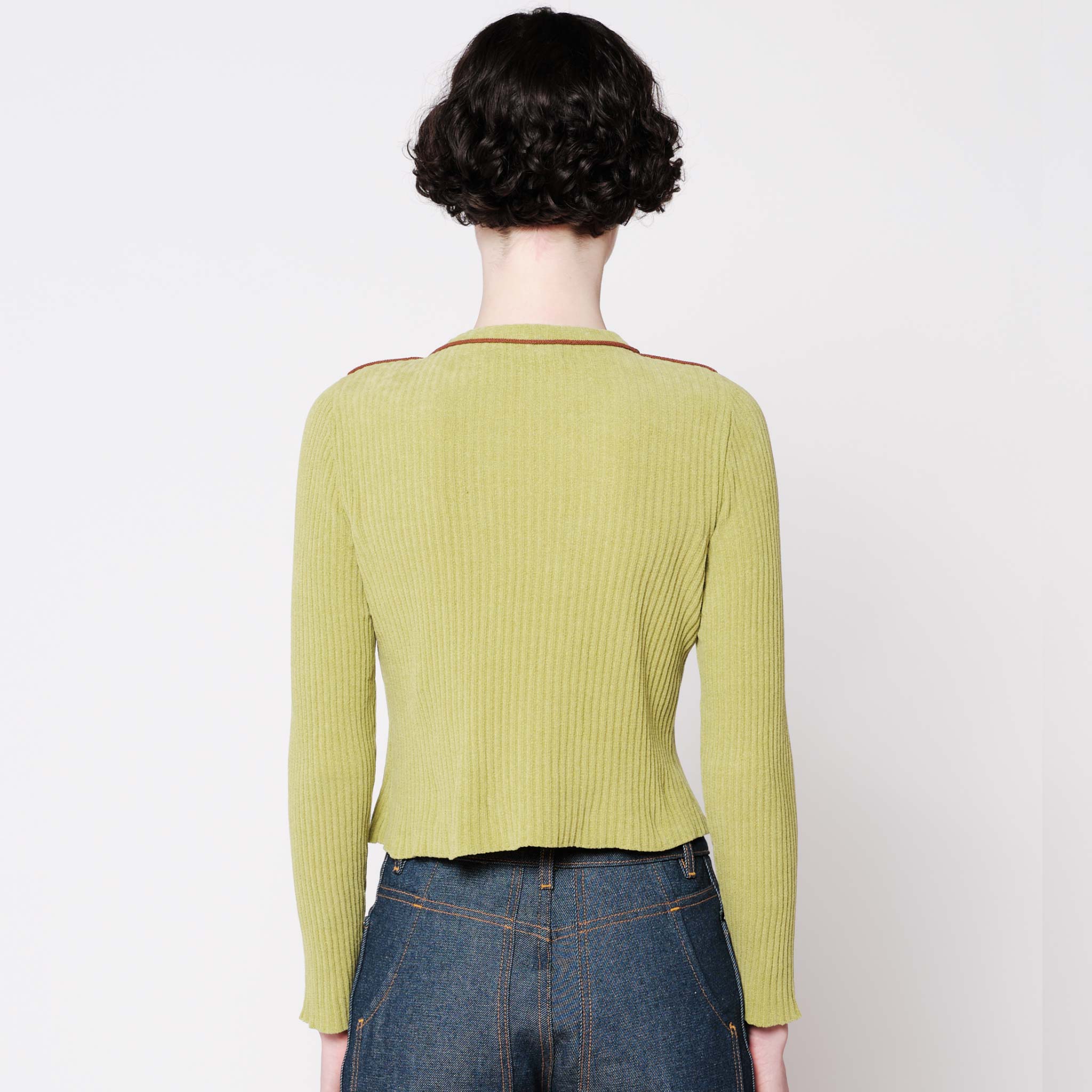 Back half body photo of model wearing the Angle Cardigan - Lime.