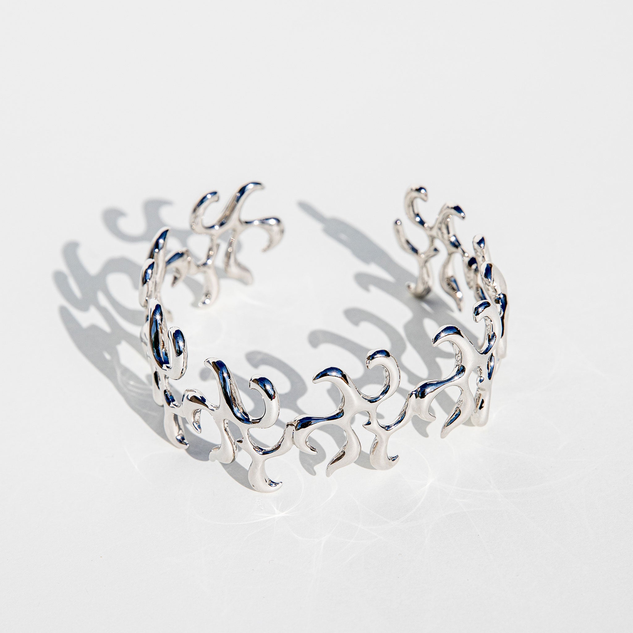 Flat photo of the silver Arm Cuff.