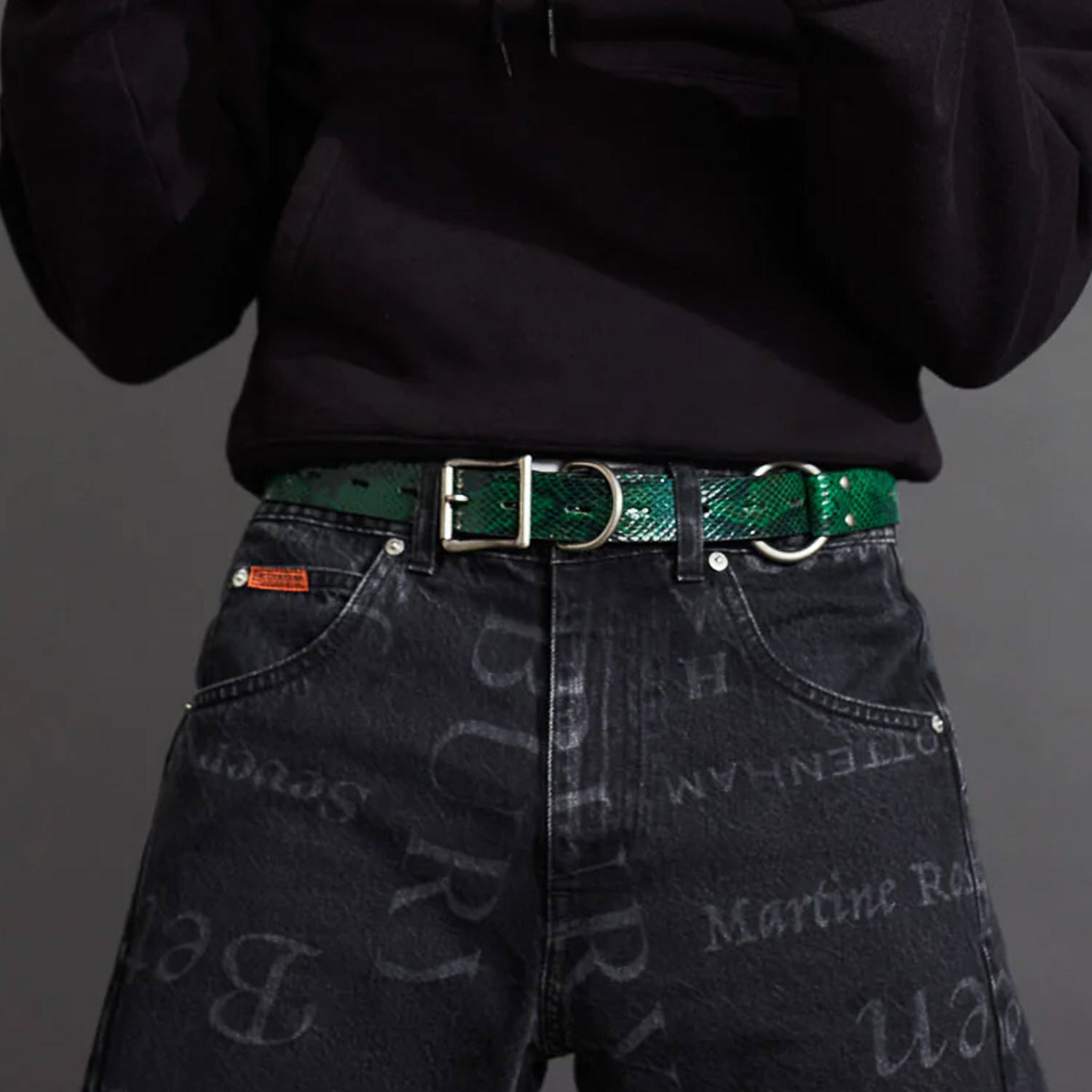 A model wears the green faux snake embossed Bondage Belt by Martine Rose.