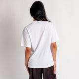 Back photo of a model wearing the white Aries Boobs short sleeve t-shirt featuring a black and white photo print of covered breasts.